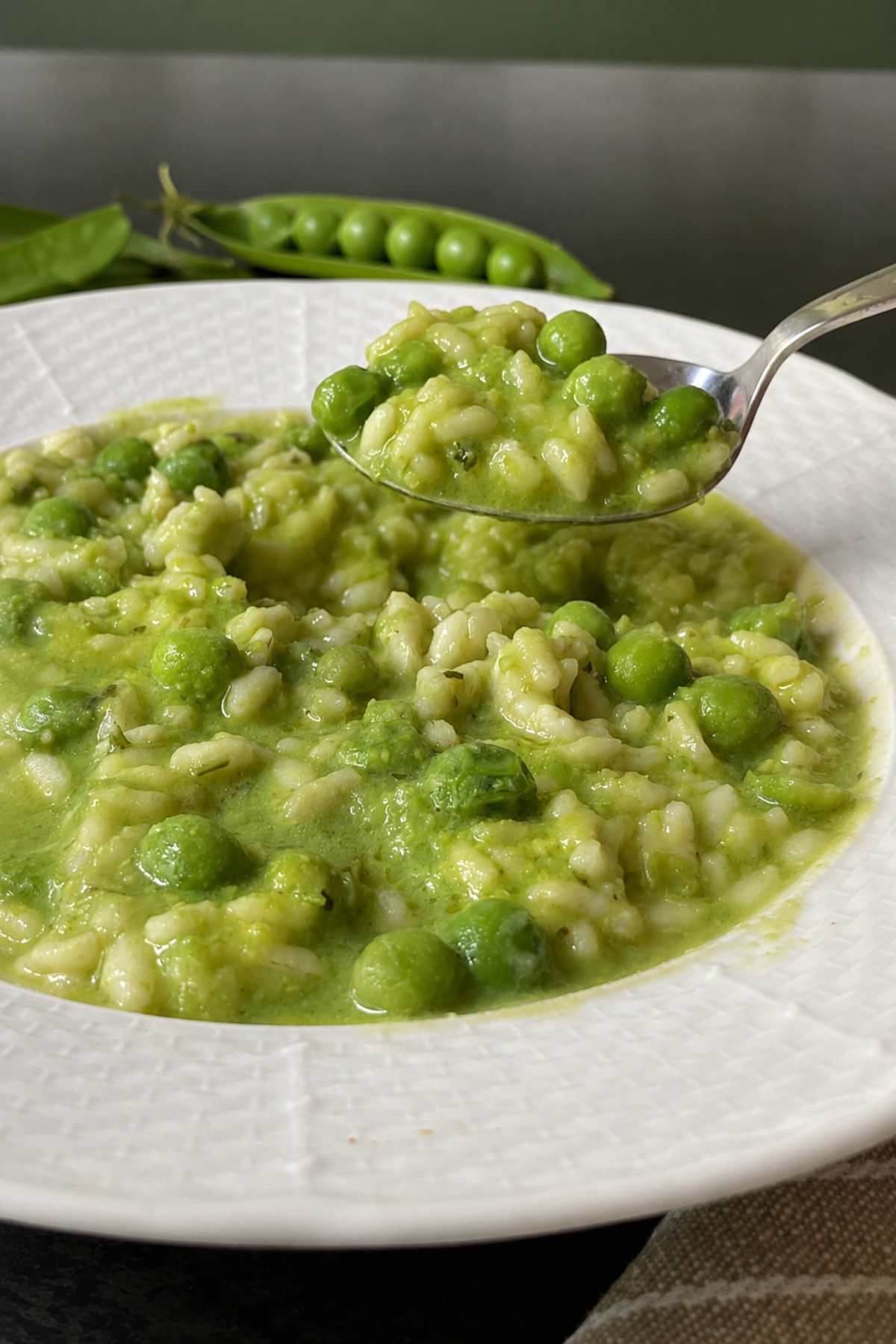 Creamy Risi e Bisi with rice and peas on a spoon