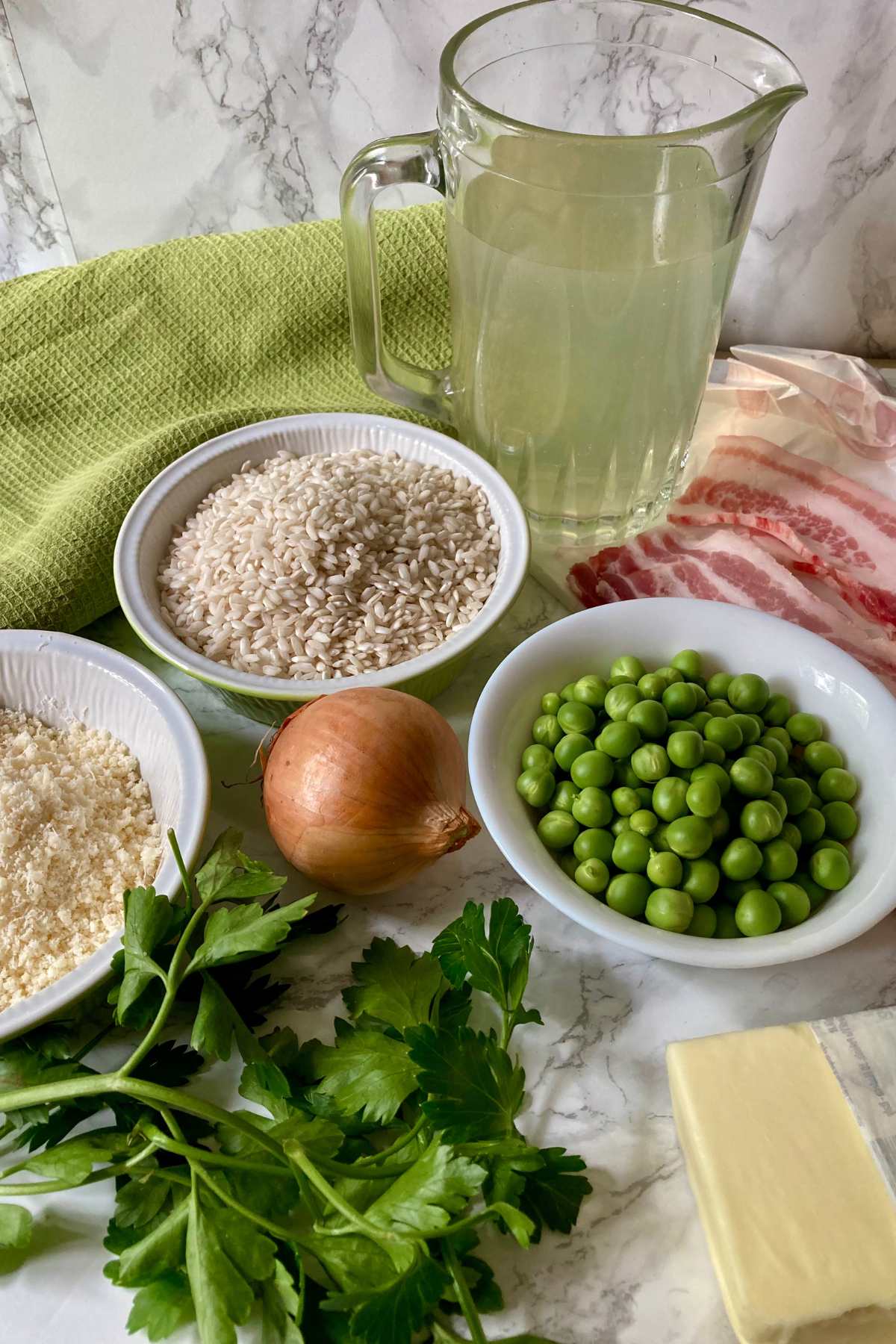 Ingredients for Risi e Bisi with rice, peas, pancetta, onion, butter, Parmigiano Reggiano and broth