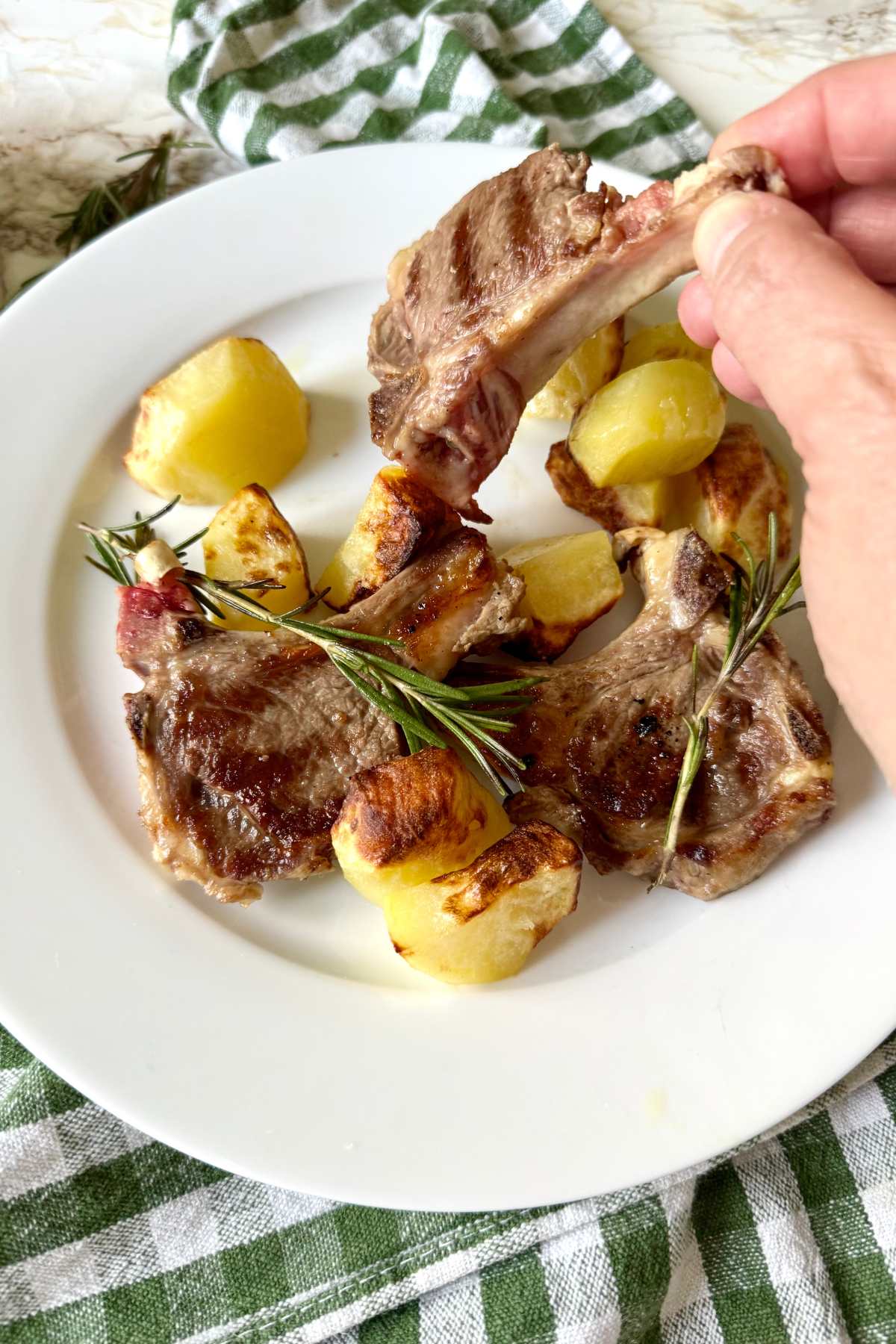 Eating abbacchio a scottadito with hands, traditional Roman lamb chops