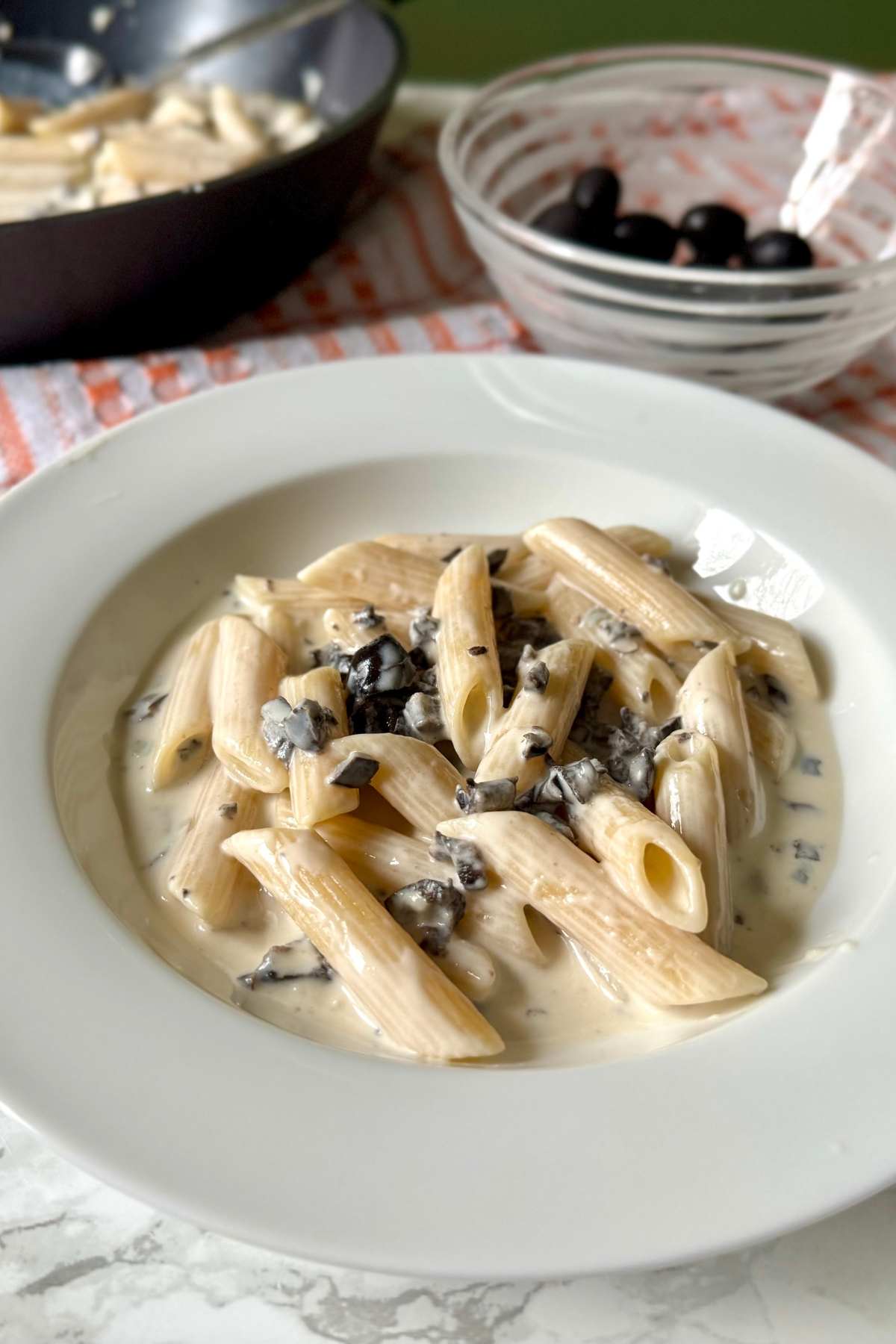 Italian pasta alla cenere with gorgonzola and black olives, creamy pasta recipe ready to serve