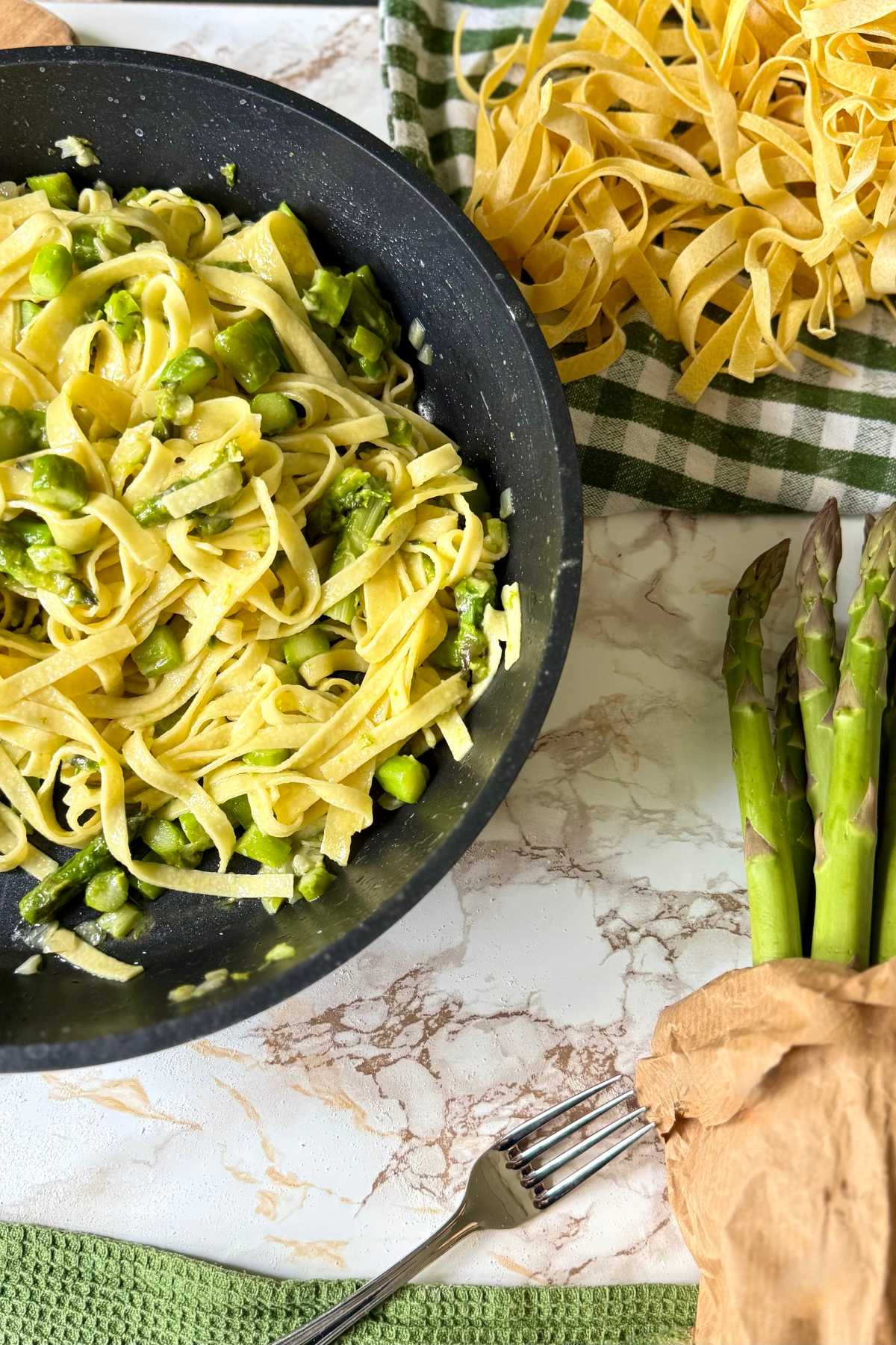 Tagliatelle with asparagus cooking in a pan with butter sauce