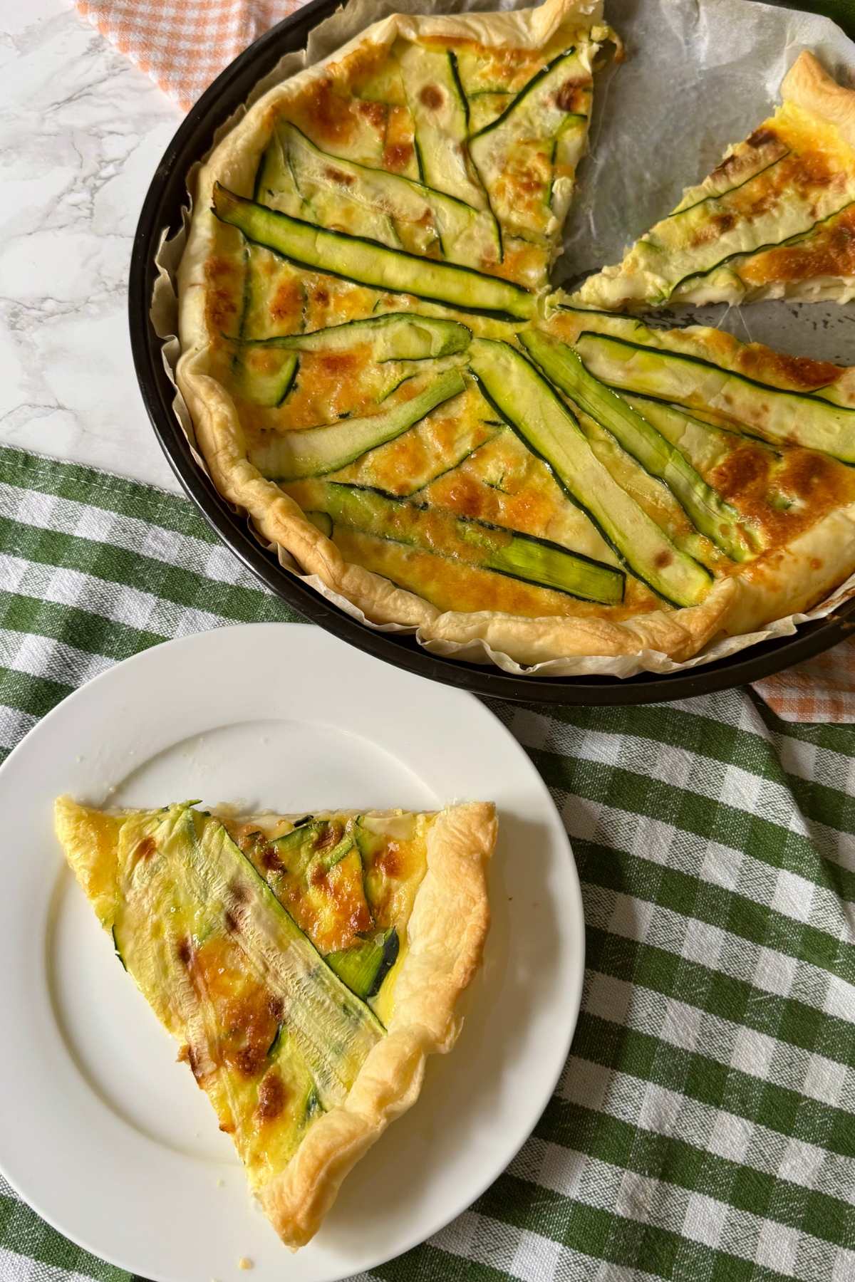 Slice of zucchini and smoked scamorza pie served on a plate with puff pastry crust