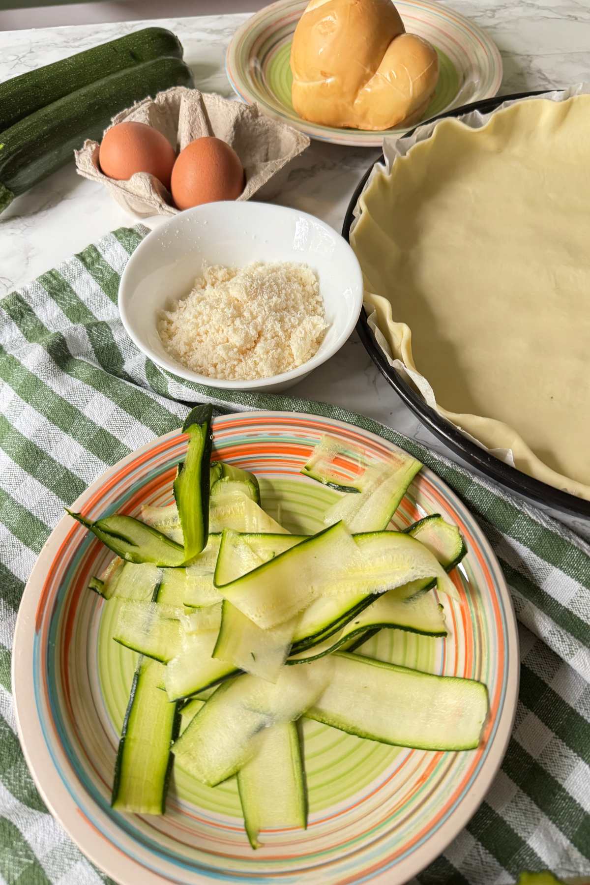 Ingredients for zucchini and smoked scamorza pie with zucchini slices, eggs, cheese and puff pastry