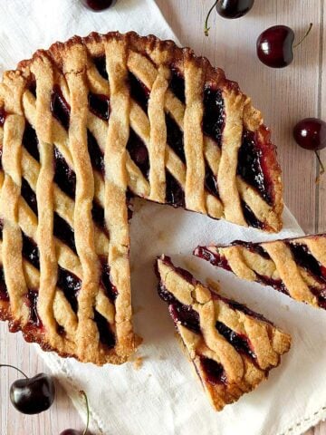Fresh cherry crostata with pasta frolla lattice crust and sliced pieces