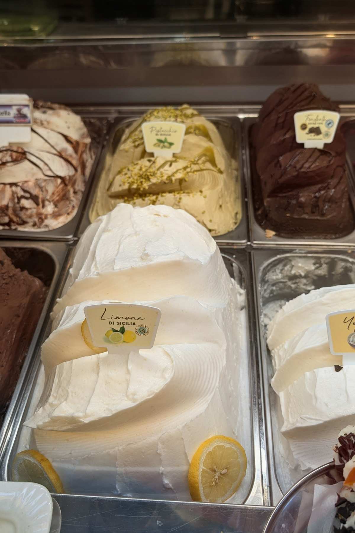Italian gelato display with lemon gelato and traditional flavors in a gelateria