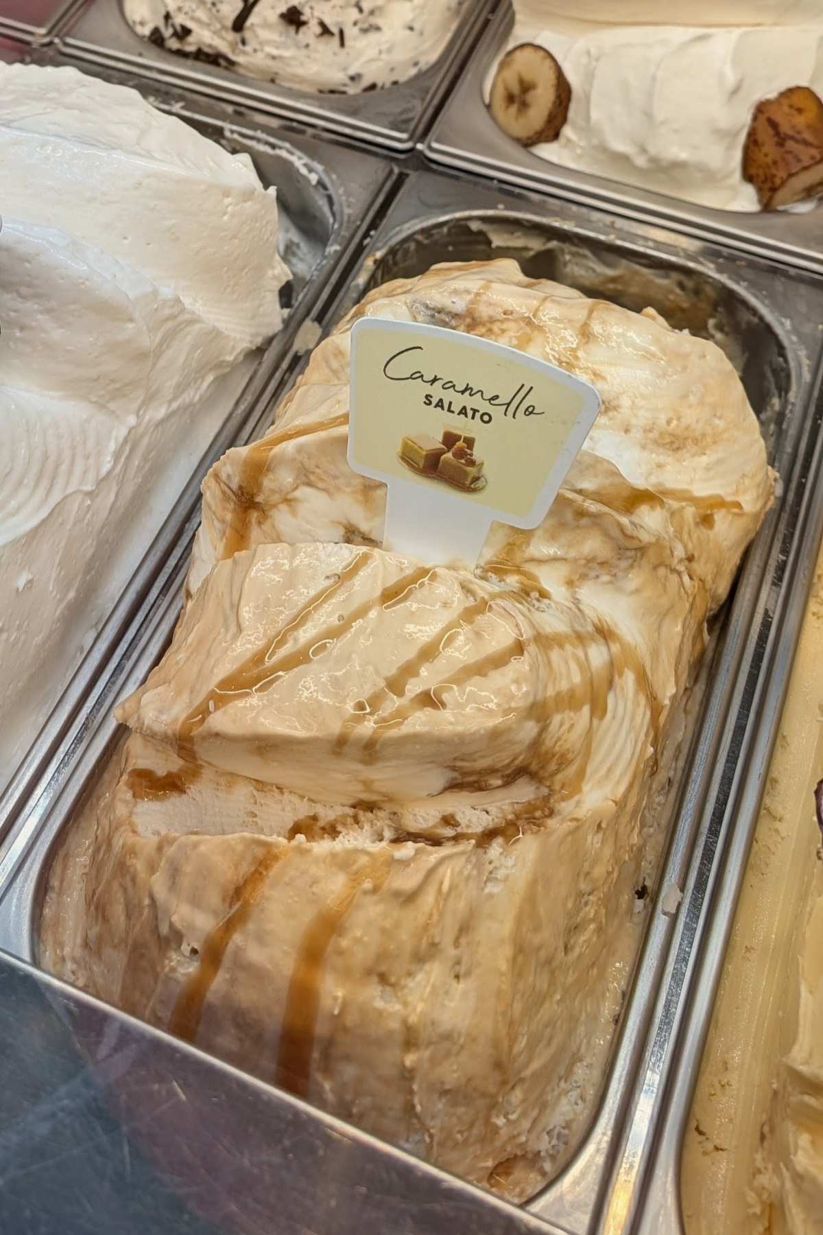 salted caramel gelato in a metal tray inside a traditional Italian gelateria