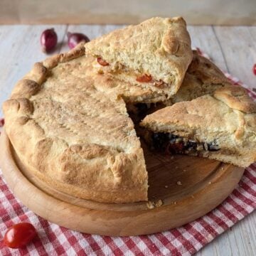 Stuffed Focaccia Pugliese with soft potato dough, tomatoes, olives and onions