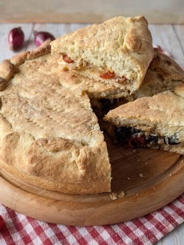 Stuffed Focaccia Pugliese with soft potato dough, tomatoes, olives and onions