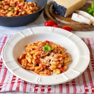 Traditional Cavatelli al Sugo Vedovo with tomato sauce, Italian lardo, grated pecorino and fresh basil